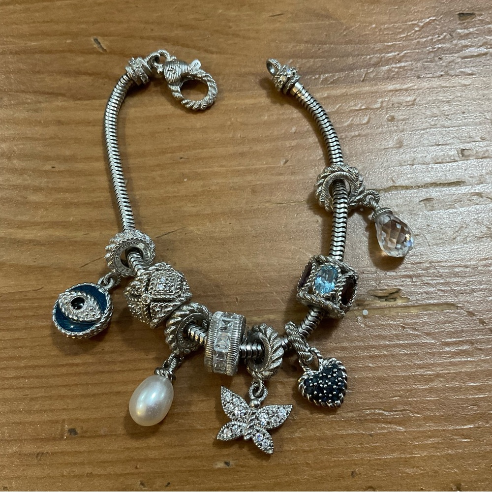 Judith Ripka: 8 cubic zirconia charms on a sterling silver (925) bracelet.